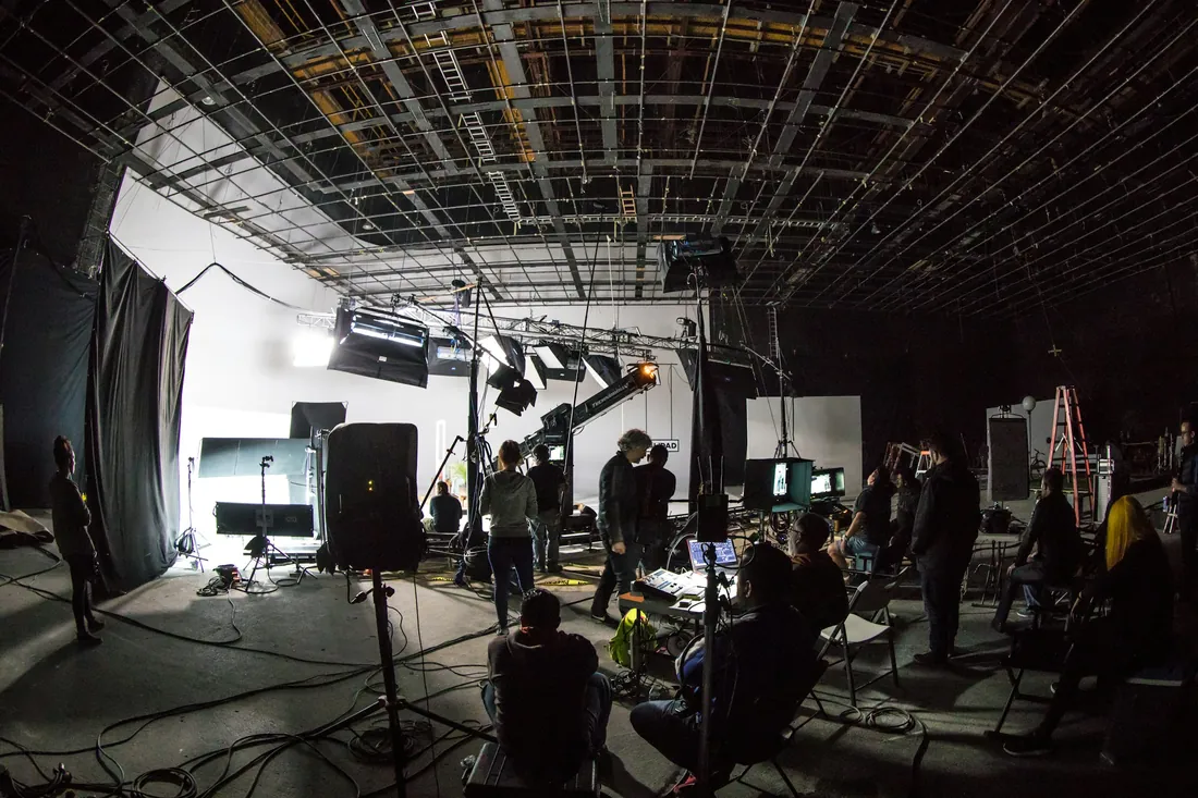 Équipe préparant les éclairages et les caméras sur un plateau de studio